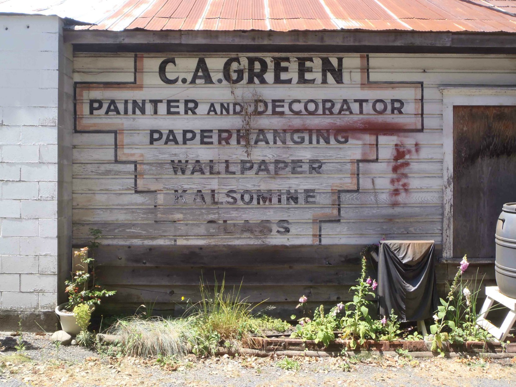 This sign, circa 1940, is still visible on the east side of 161 Kenneth Street, Claude Green's former business premises